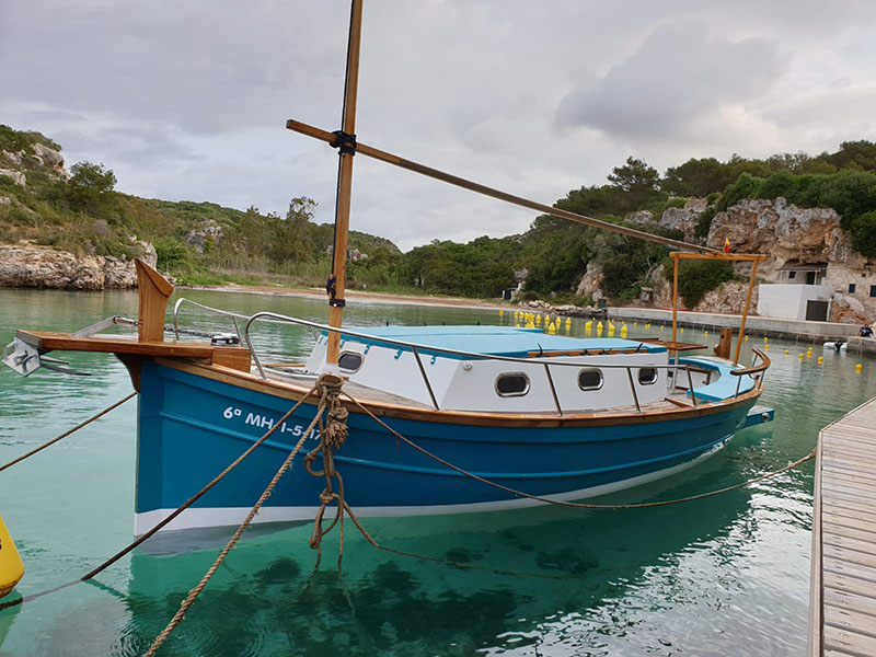 Barco en Menorca navegando por aguas turquesa
